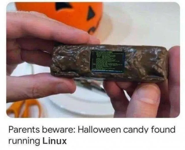 Hands holding a chocolate bare that has a terminal screen in it. The caption says: "Parents beware: Halloween candy found running Linux"