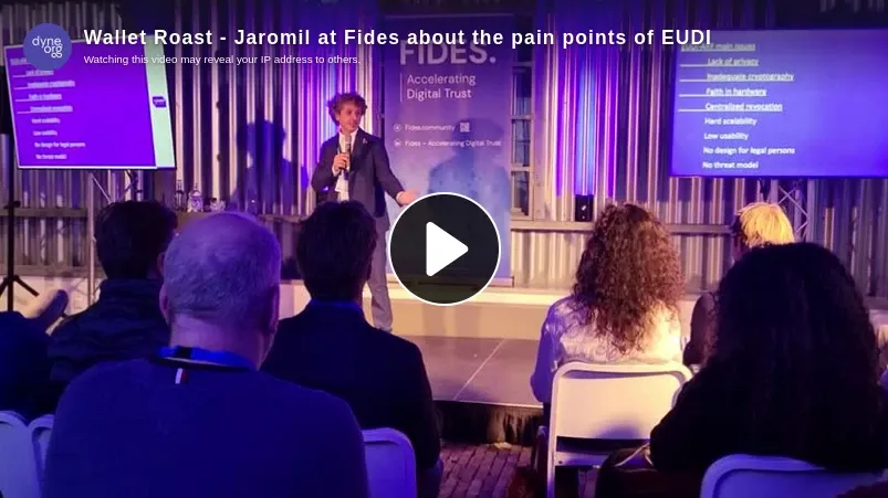 Thumbnail of the "Wallet Roast" talk by Jaromil at Fides (linking to the video) about the pain points of EUDI. We see Jaromil in front of a crowd, looking happy and holding a microphone. The room is lit with purple light.