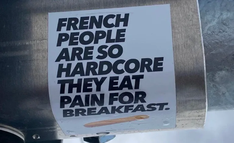 A sticker that shows a baguette under the text "French people are so hardcore they eat pain for breakfast."